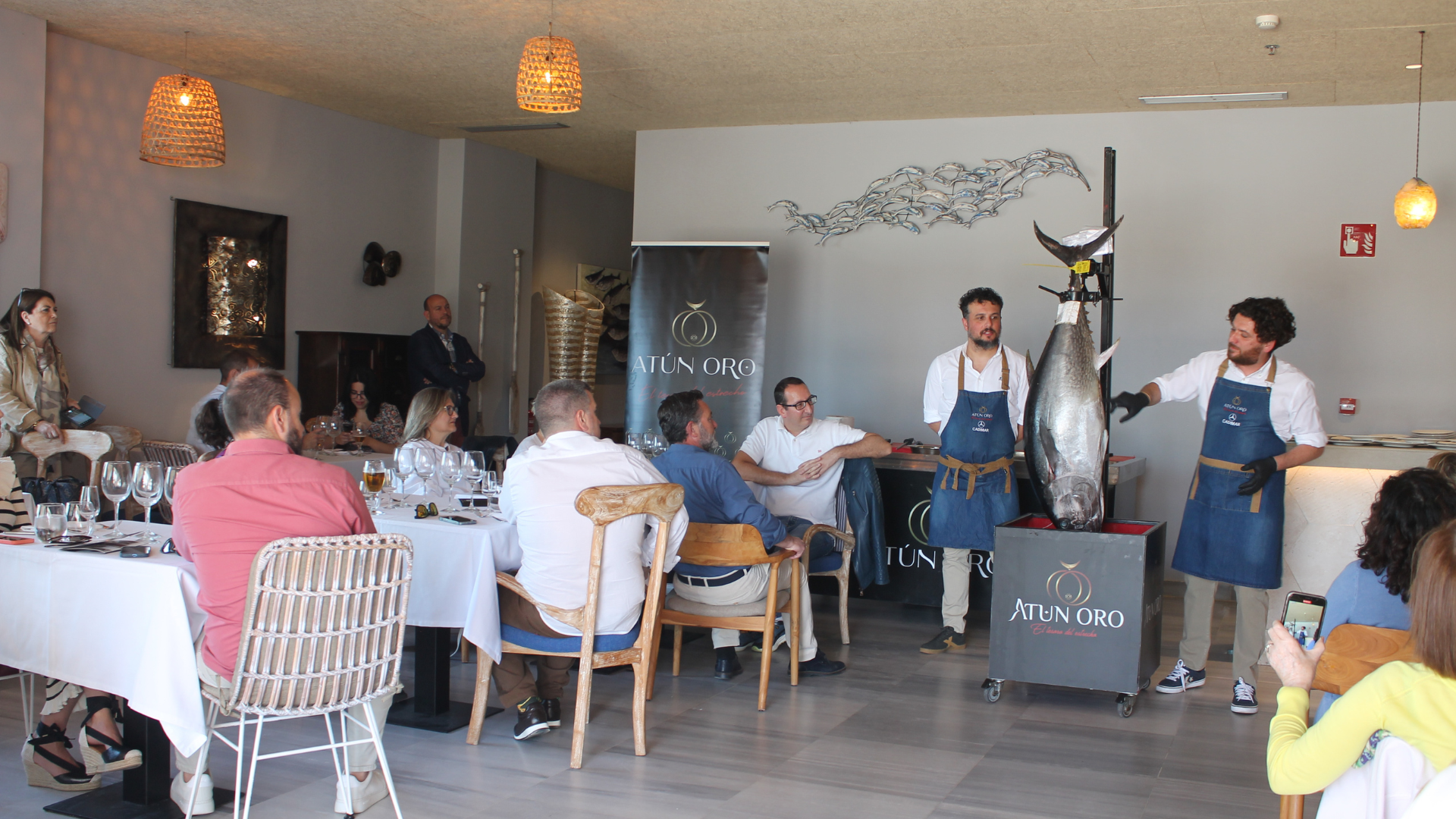 Chef especializado en ronqueo de atún presentando el atún fresco durante una demostración en vivo en un evento, explicando el proceso a los asistentes.