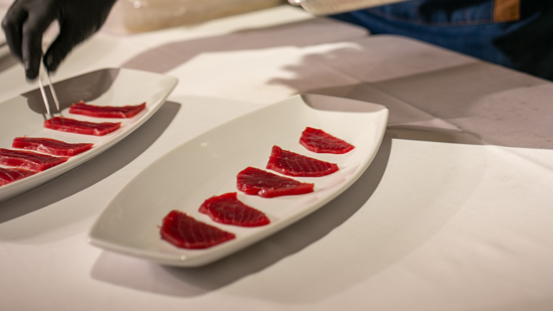 Platos con sashimi de Atún oro (Tunoro) meticulosamente colocados, presentados elegantemente para un evento exclusivo tras un show de ronqueo de atún.