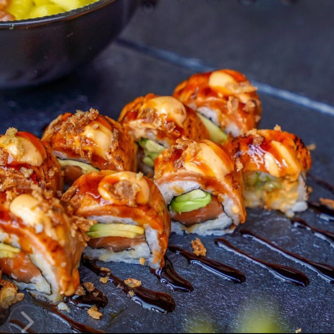 Plato de salmón fresco sobre arroz japonés, decorado con cebolla frita crujiente para un toque gourmet