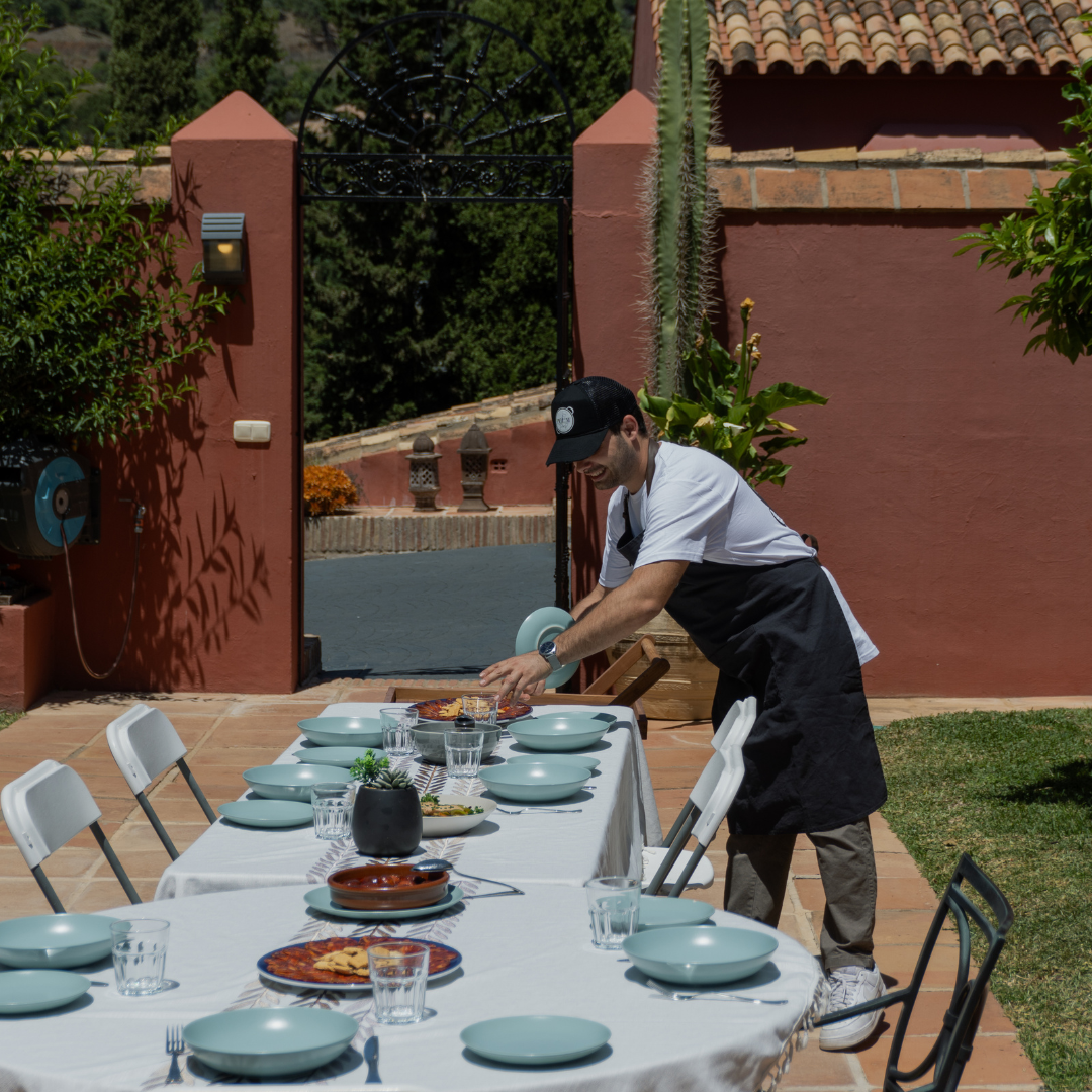 Chef arrocero preparando la mesa de los comensales antes de servir la paella en un evento privado, asegurando una experiencia perfecta.