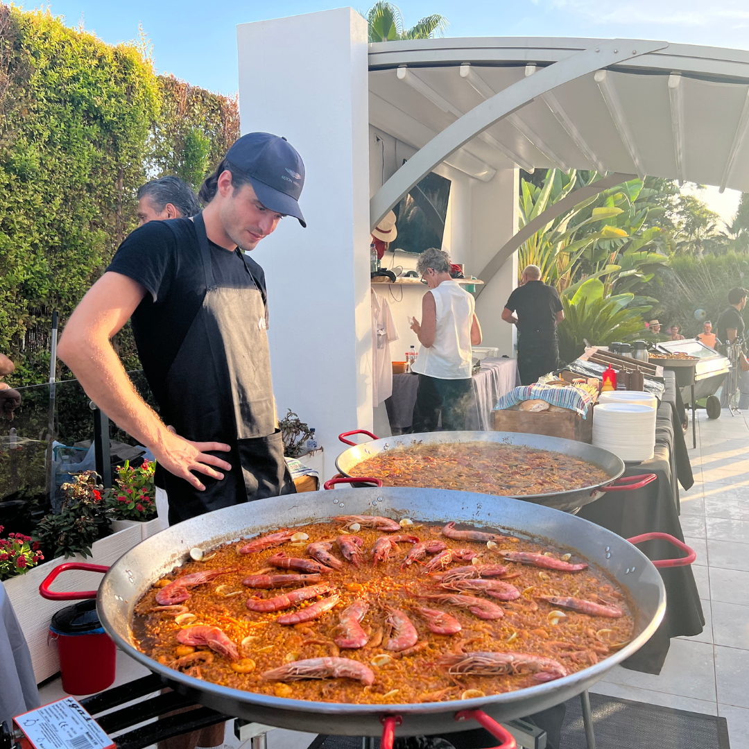Arrocero cocinando dos paellas gigantes al mismo tiempo durante un evento, mostrando habilidad y precisión en la preparación.