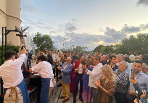 Chef especializado en ronqueo de atún realizando una demostración en vivo en un evento multitudinario, mostrando su habilidad y destreza ante un gran grupo de personas.